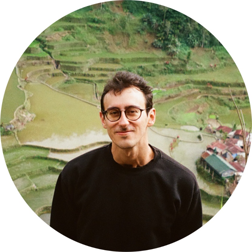 Daniel smiling above a valley of terraced rice fields